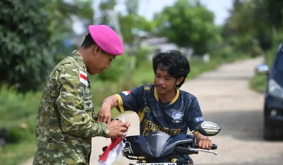 Korps Marinir TNI AL Membagikan Bendera Merah Putih kepada Warga Pulau Sebatik untuk Menyambut HUT Ke-81 RI